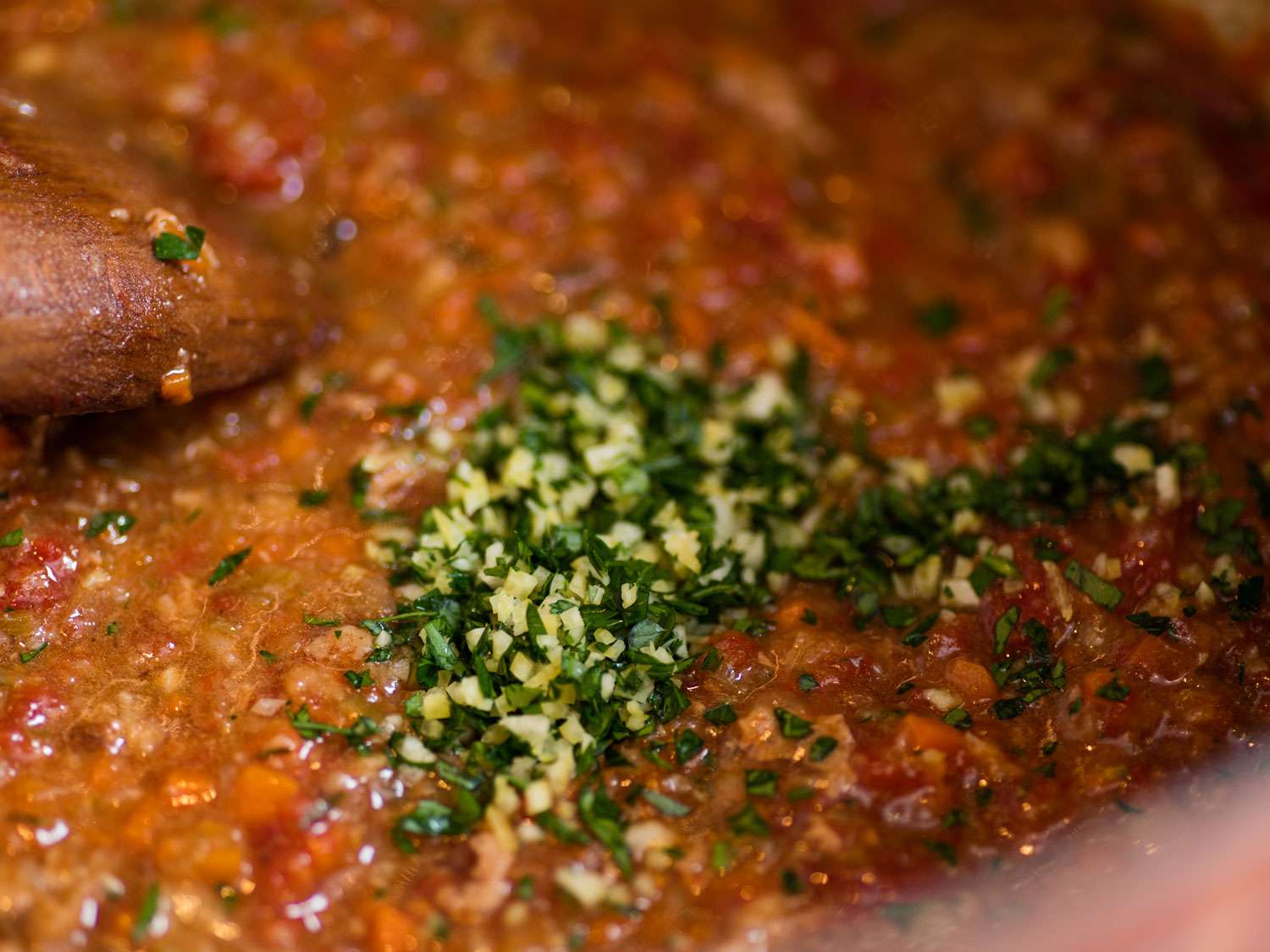 Adding gremolada to pot of osso buco.