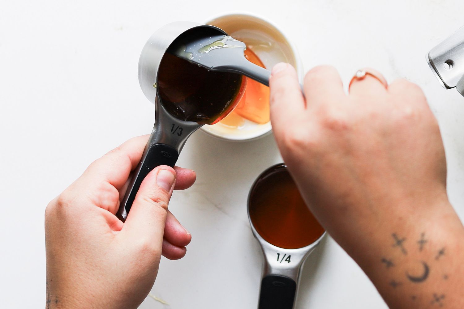 Scraping honey from OXO Stainless Steel Measuring Cups