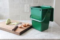 Exaco Eco 2000 kitchen compost pail on a counter next to a cutting board