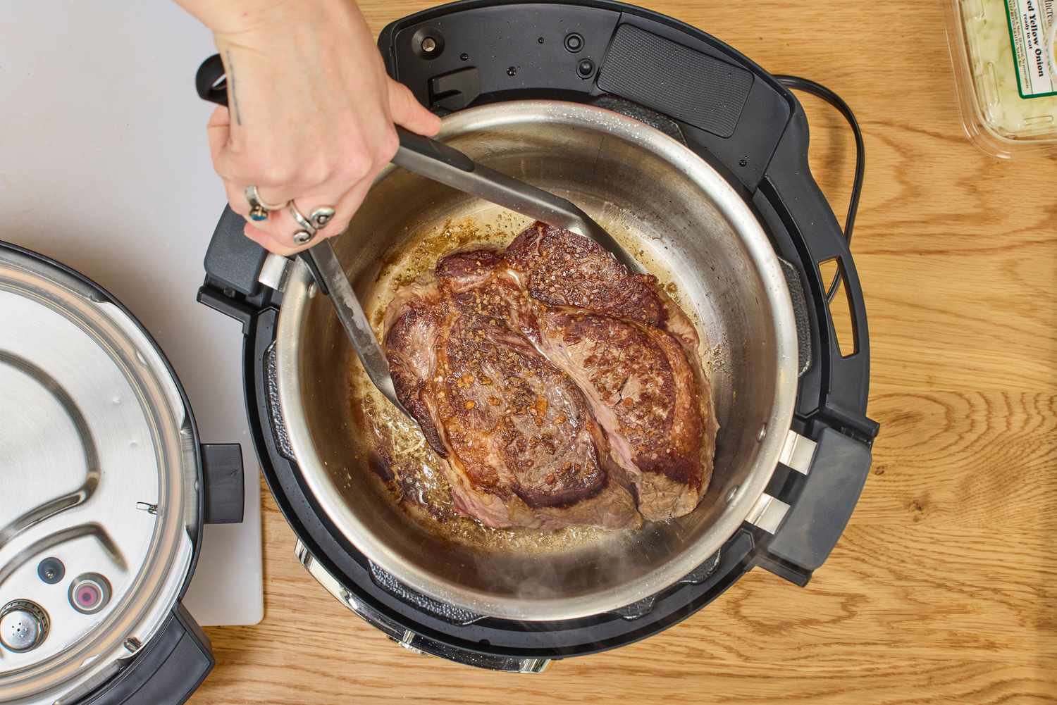 A person cooks meat in the Instant Pot Pro Plus Wi-Fi Smart 10-in-1 6-Quart Pressure Cooker
