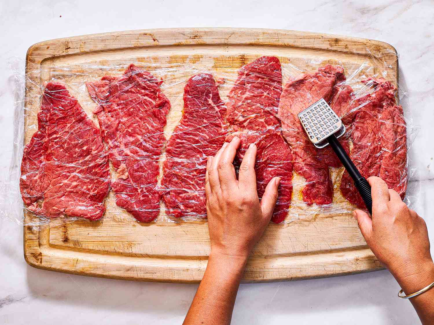 Overhead view of pounding steaks 