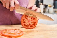 A person slicing a tomato with the Misono 8.2 Inch Molybdenum Gyutou
