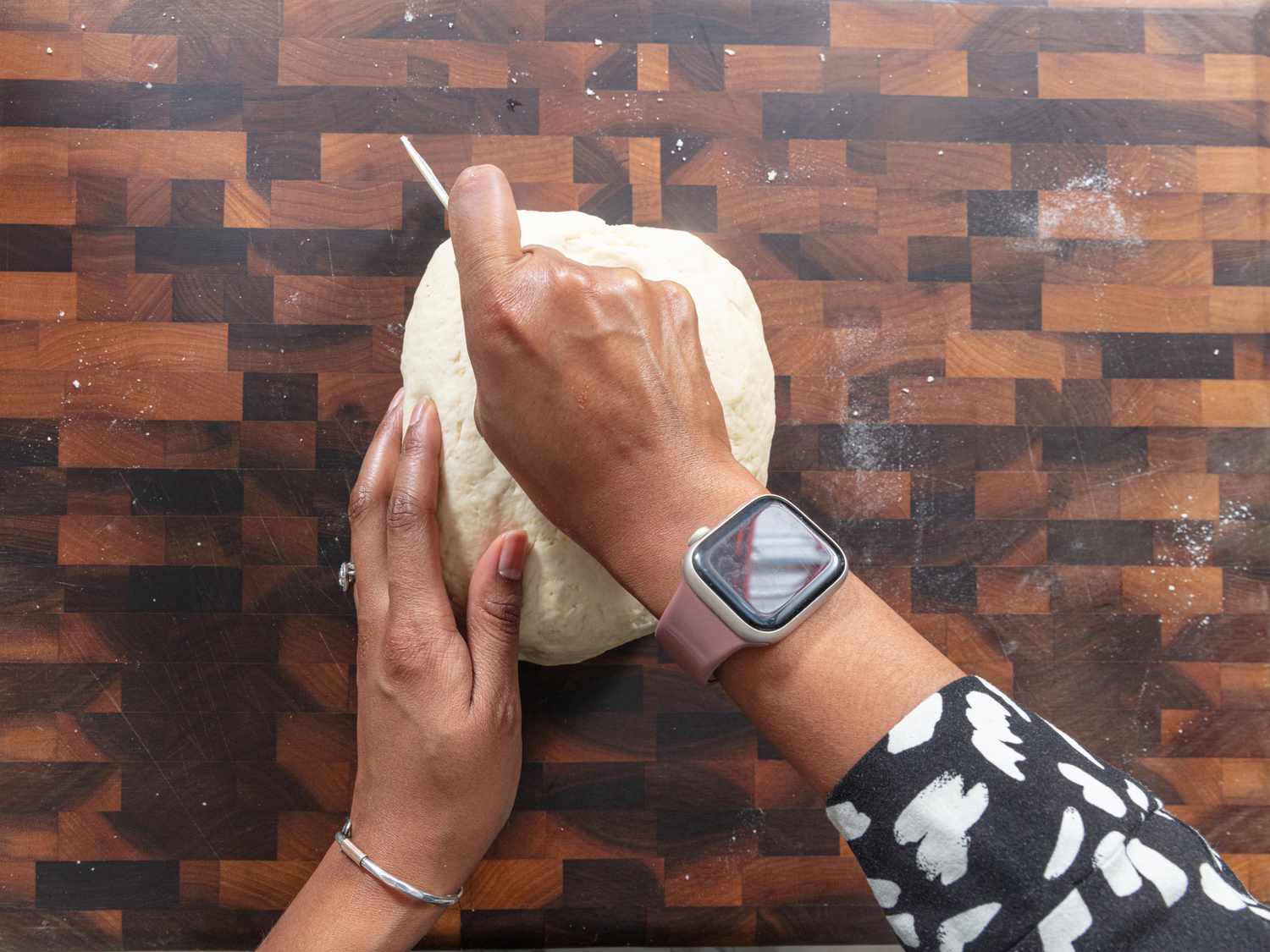 Cutting dough in halves on a wooden chopping block 