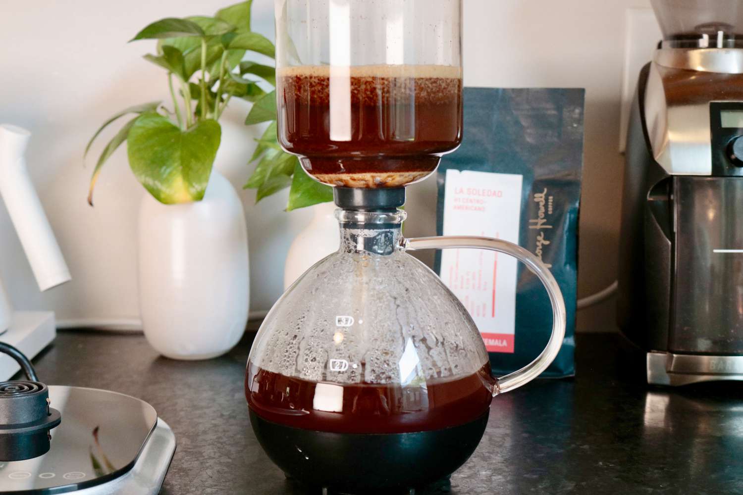 coffee traveling from the top of a siphon brewer down to the base