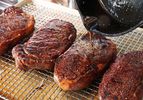 Hot pan drippings are poured on seared and rested steaks to "fat flash" them.