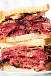 Pastrami sandwich on rye brad with golden mustard.