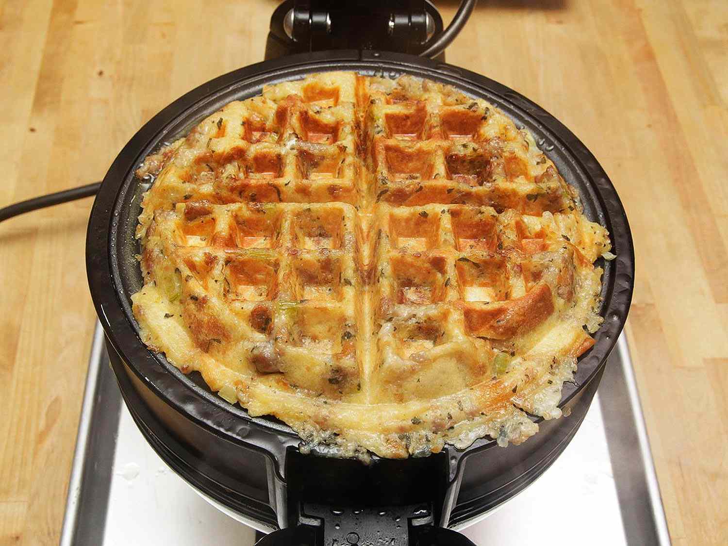 An open waffle iron showing a cooked stuffing waffle.