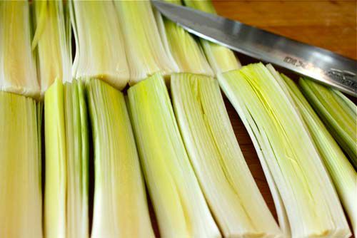 Rows of raw leeks cut lengthwise.
