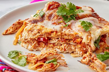 Mexican pastel azteca dish served on a plate garnished with fresh cilantro and melted cheese