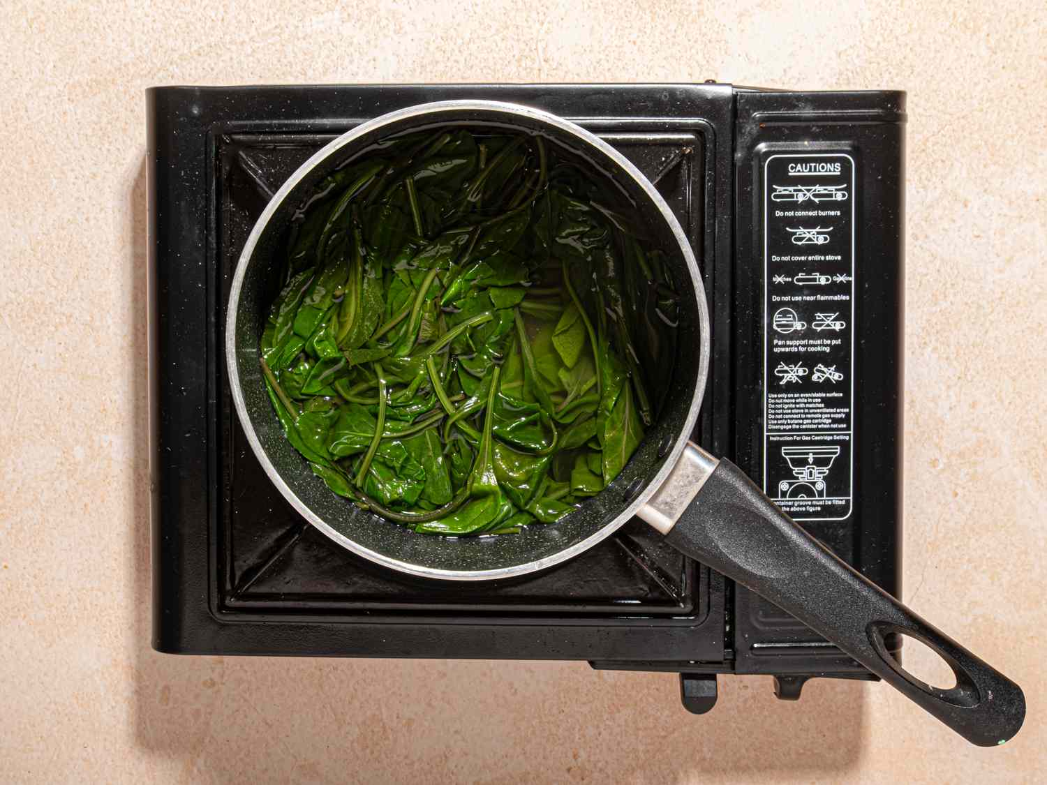 A pot of leafy greens being cooked on a stovetop