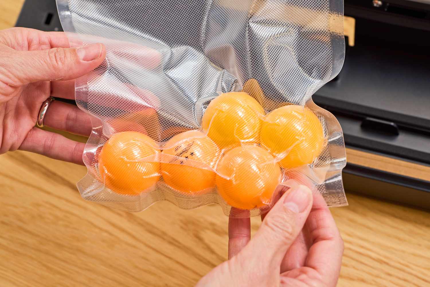 A bag of ping pong balls is vacuum sealed using the Anova Precision Sous Vide Vacuum Sealer