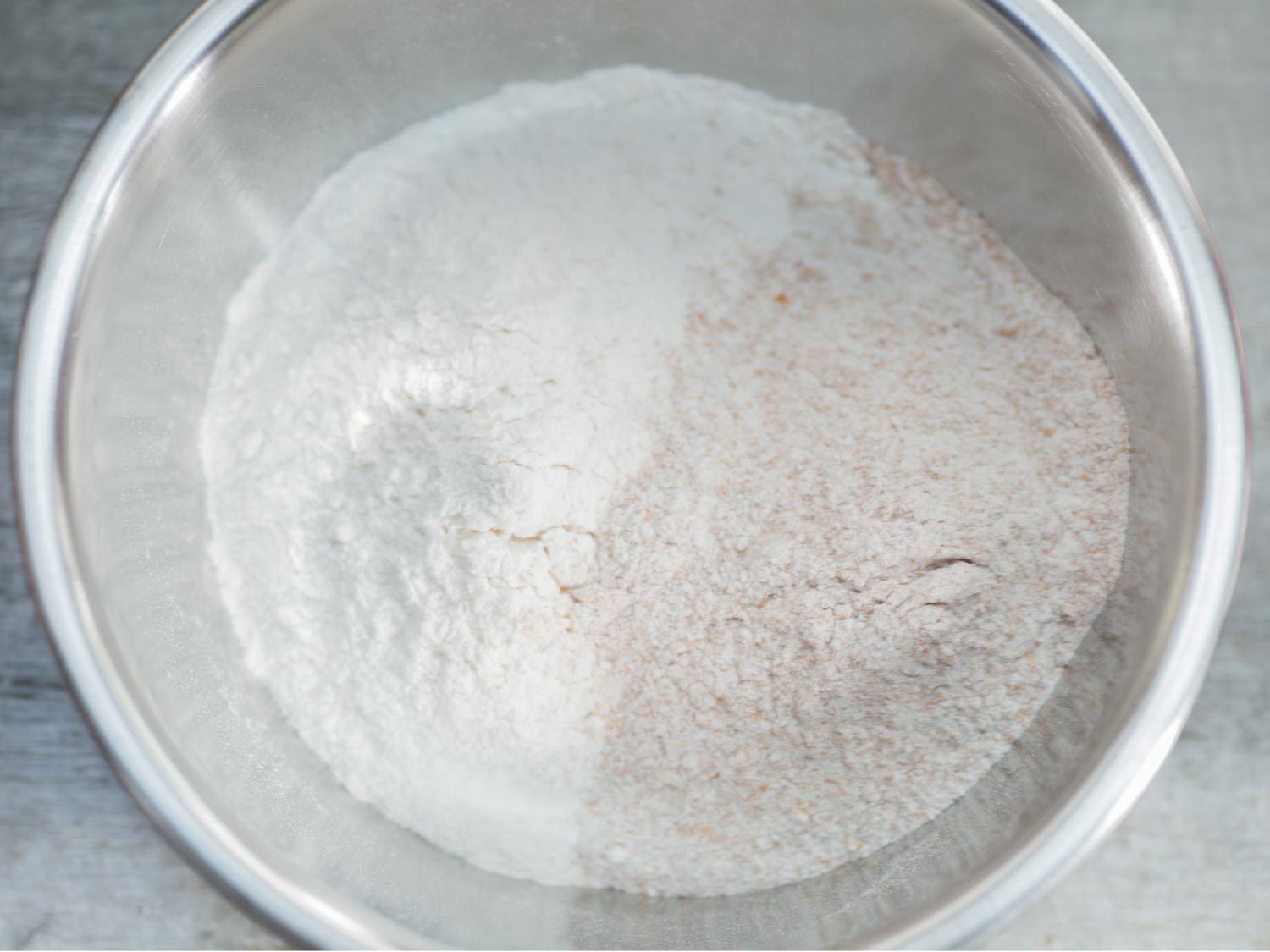 A prep bowl containing a mixture of all-purpose and whole wheat flour.