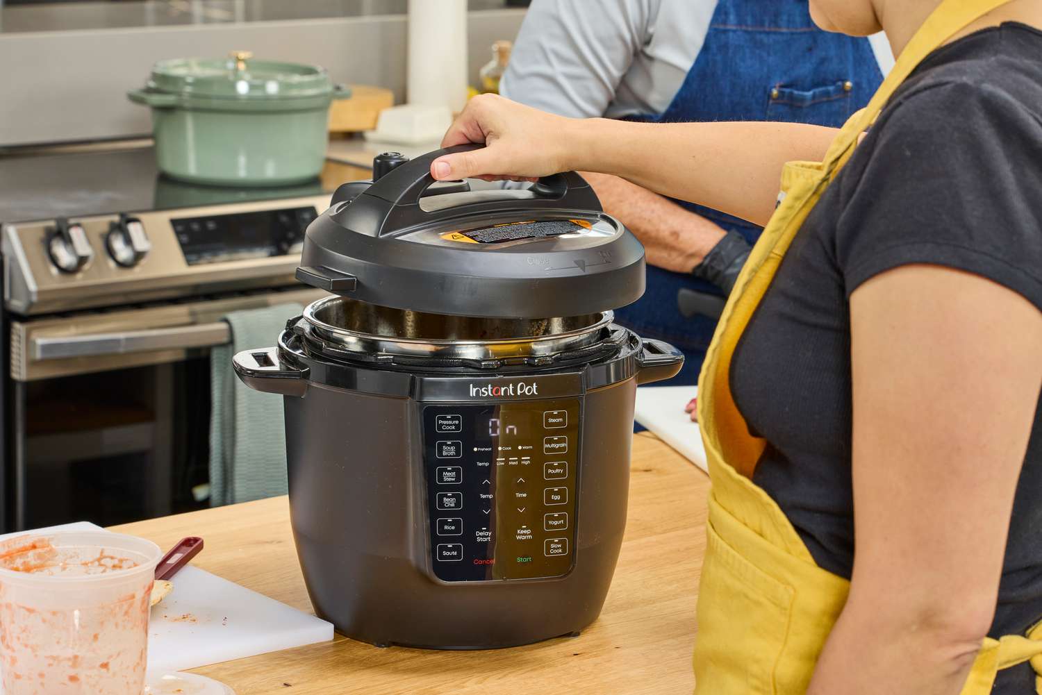A person removes the lid on the Instant Pot RIO 6-quart Multicooker