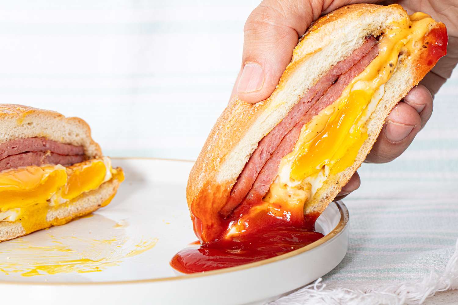 Pork roll half dipped in ketchup.