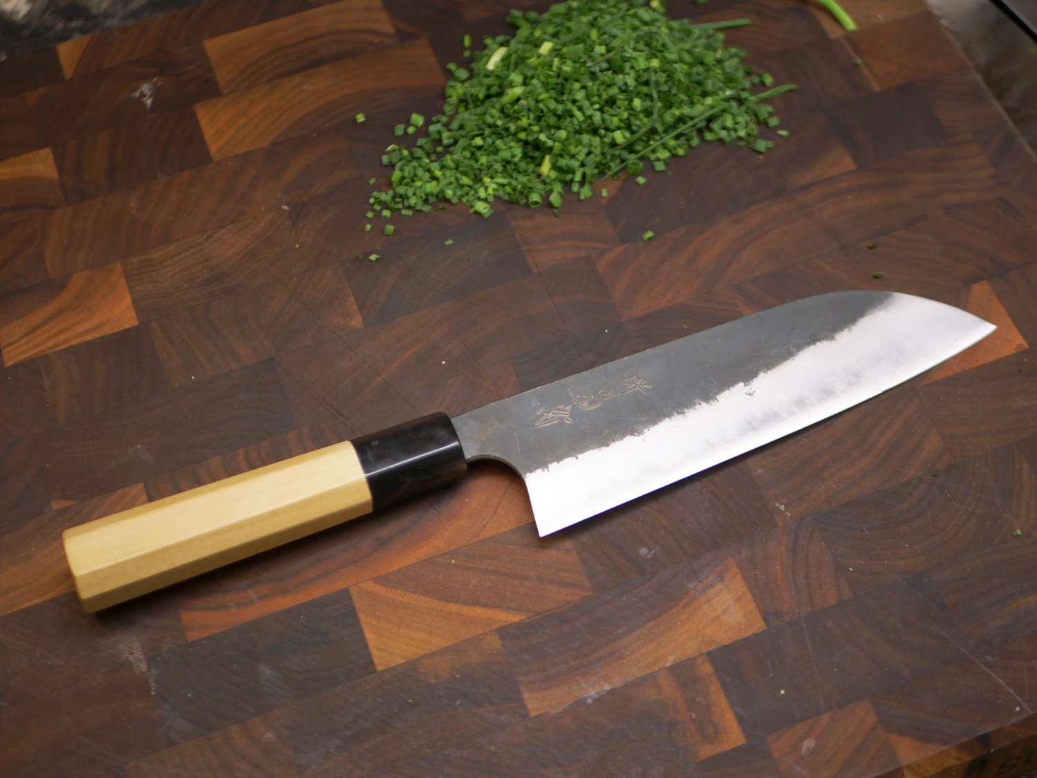 sakai kikumori santoku on a wooden cutting board