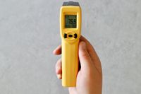 The ThermoWorks infrared thermometer in someone's hand.
