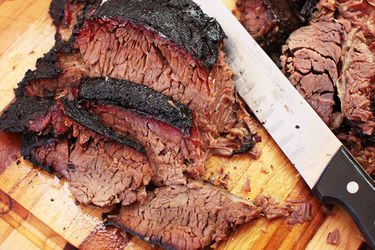 Sliced barbecued smoked beef chuck on a cutting board. 