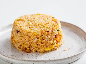 A mound of instant ramen fried rice on a speckled stoneware plate.