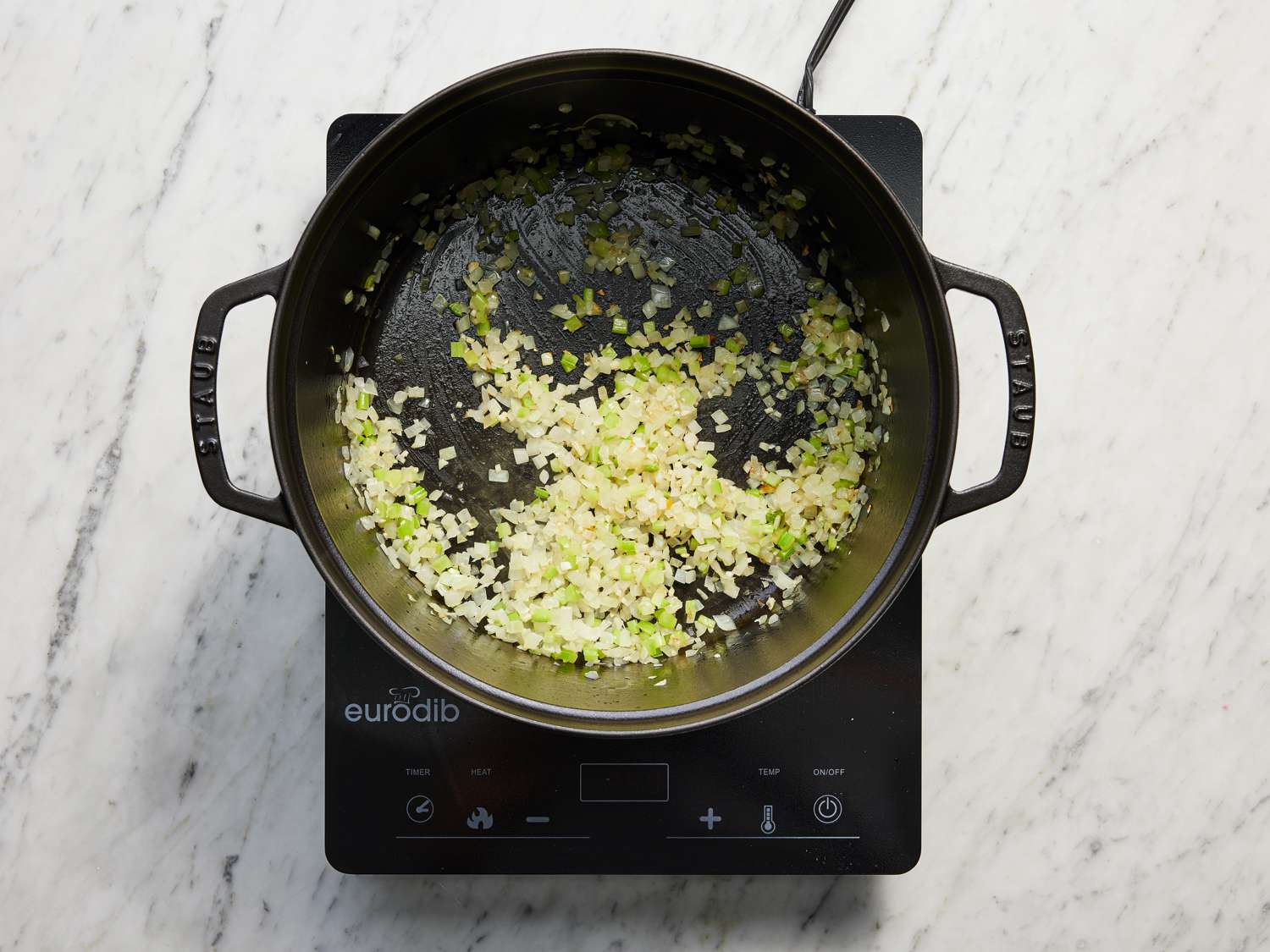 Celery and onion cooking in a large dutch oven