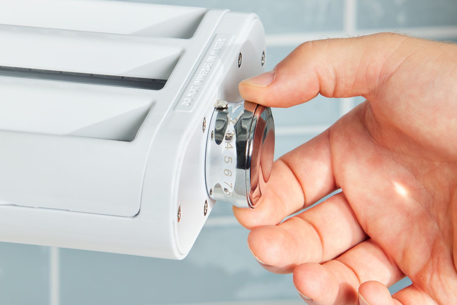 A person adjusts the Antree Pasta Maker Attachment 3 in 1 Set for KitchenAid Stand Mixers