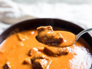 A spoonful lifted from a bowl of rich Ghanaian goat and tripe soup. 