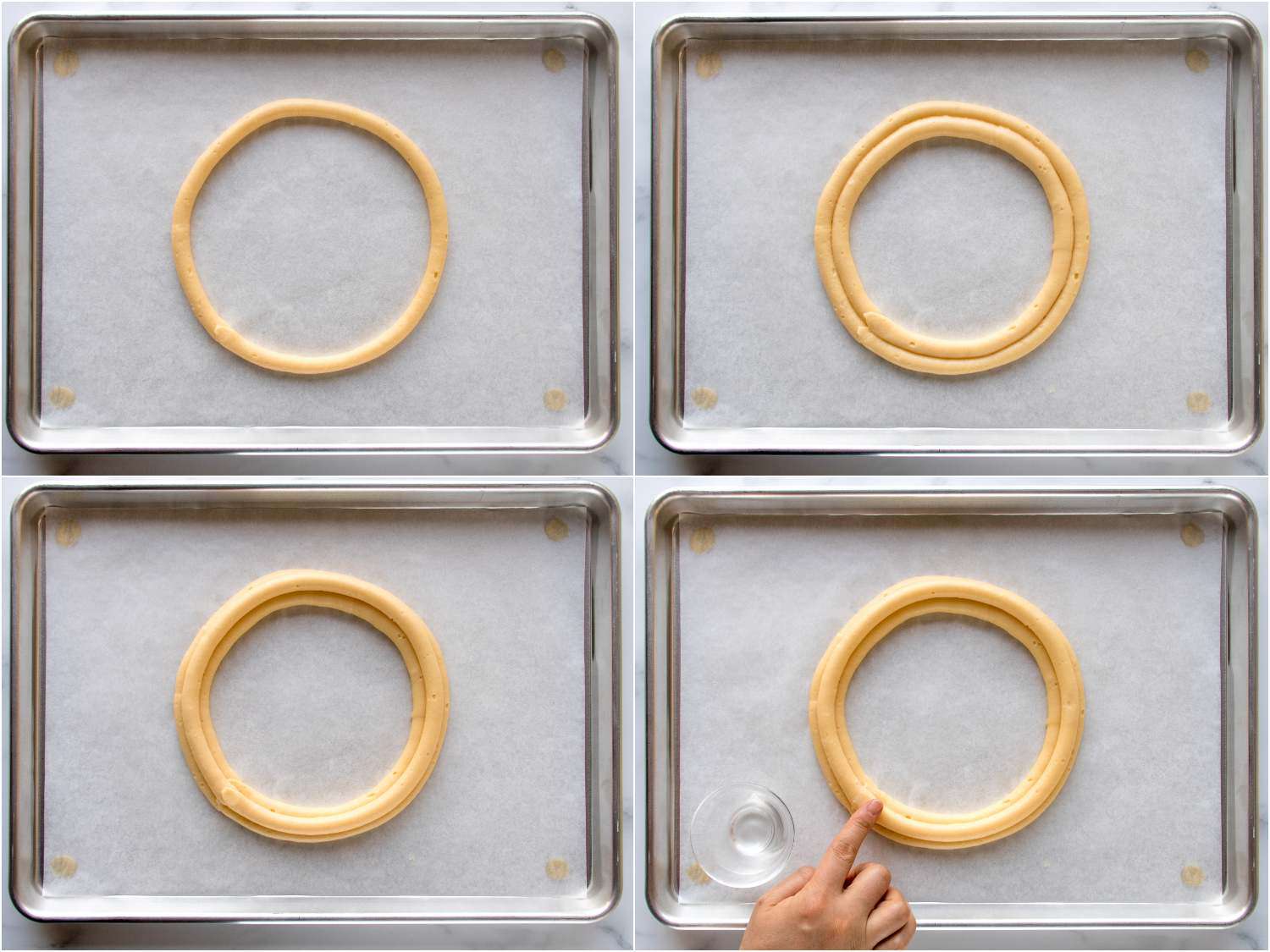 A four-image collage. The top left image shows a ring of choux piped out in a circle on parchment paper on a baking sheet. The top right image shows a ring of choux piped just touching the inside of the circle from the previous image on the parchment paper. The bottom left image shows a final ring of choux on top of, and nestling in the groove between the two piped rings. The bottom right image shows a finger smoothing the surface of the dough by patting down bumps with cold water.