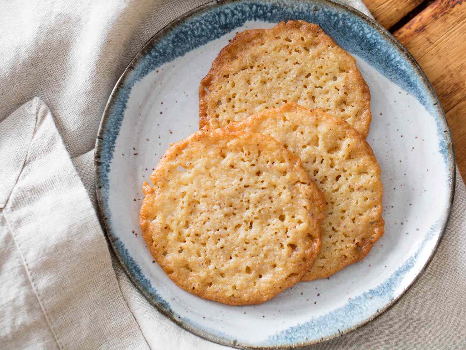 A plate of lacy brown butter and ricotta cookies.