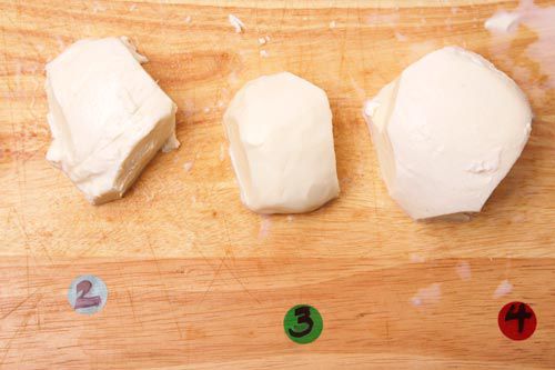 Three different types of mozzarella on a cutting board.