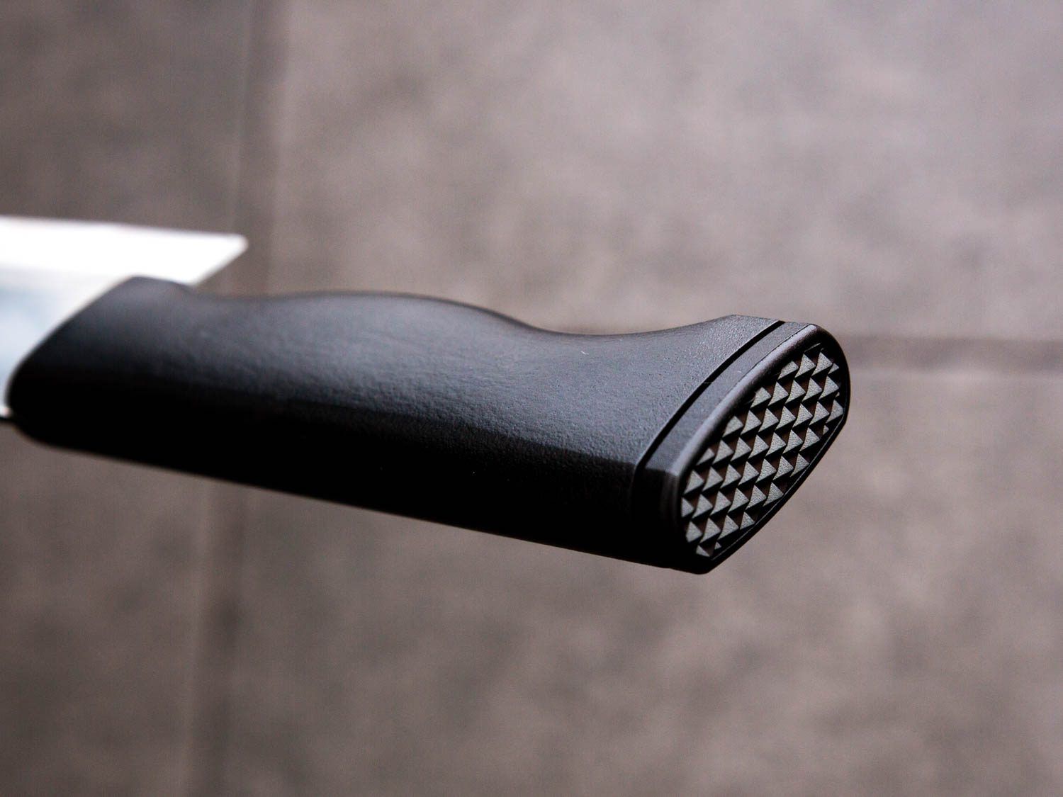 Closeup of the pommel of a Korean chef's knife. Its flat, textured surface is perfect for pounding garlic.