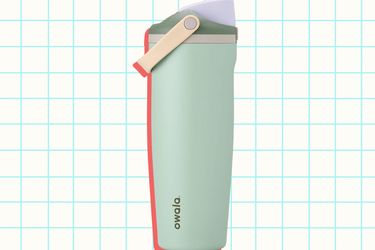 A reusable water bottle with a fliptop lid and a red accent labeled Owala shown against a checkered background