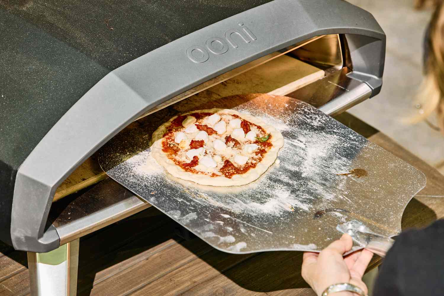 A pizza is placed into the Ooni Koda 2 Pro Gas-Powered Pizza Oven