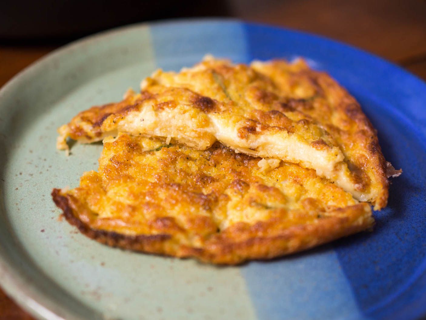 A close-up of farinata wedges on a serving plate. 