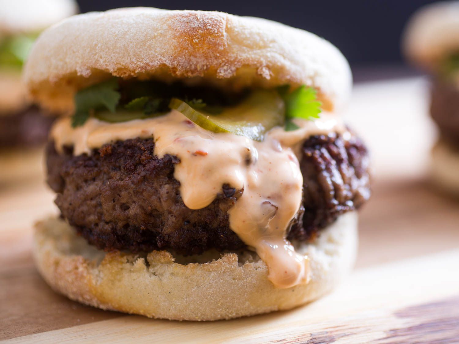 Closeup of a Sichuan Peppercorn Burger With Chile-Ginger Mayo and Cucumber Pickles.