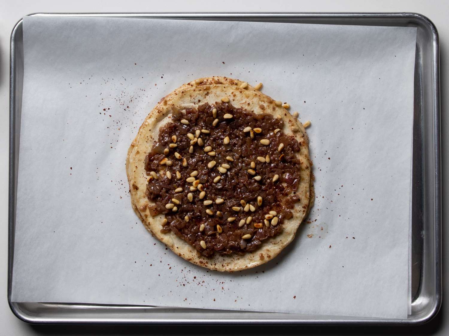 Taboon topped with reduced onions and pine nuts.