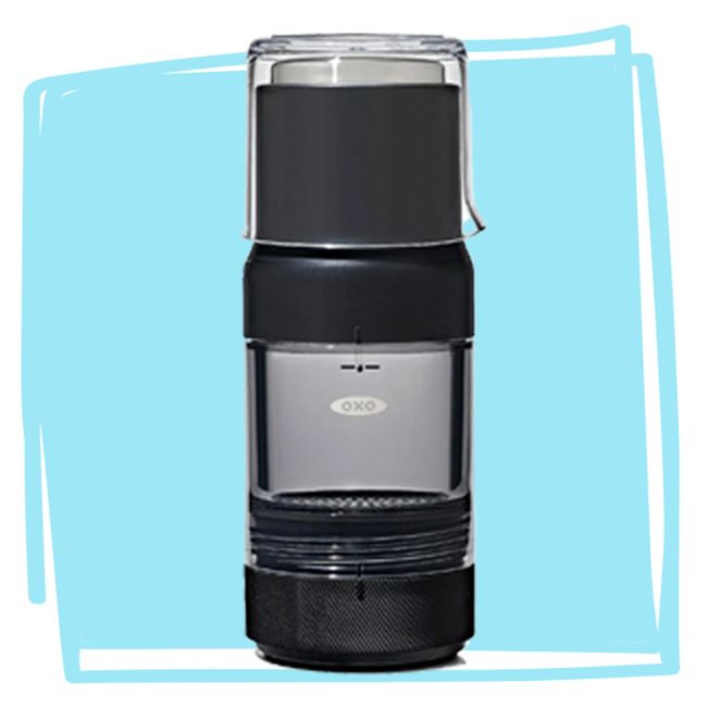 A compact beverage brewer with a modern cylindrical design featuring a transparent upper section and a dark solid lower part