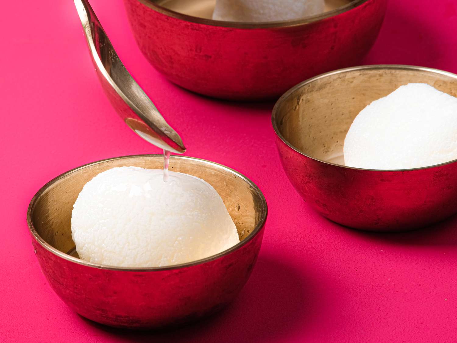 Side view of adding syrup to a rasgulla