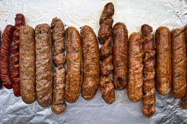 A line up of sausages grilled with different methods. 
