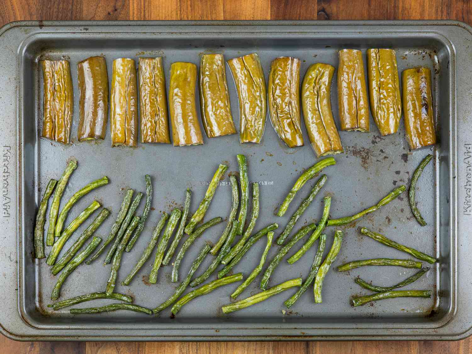 Roasted eggplant and long beans on a baking sheet