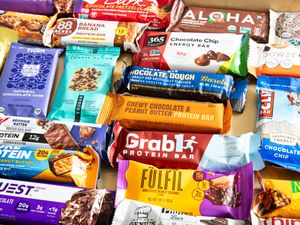A variety of protein bars placed together displaying different brands and flavors