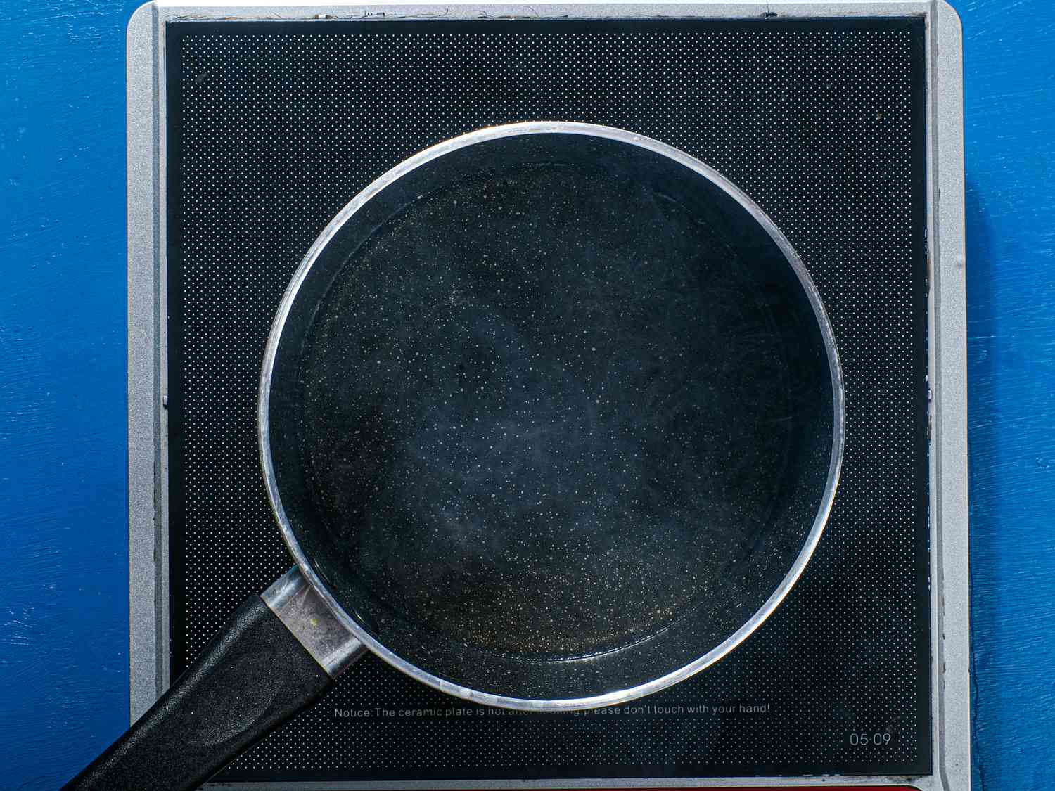 A skillet of oil is heated on an induction burner.