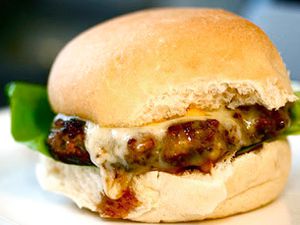 Turkey burger topped with melted cheddar cheese resting on a burger bun.