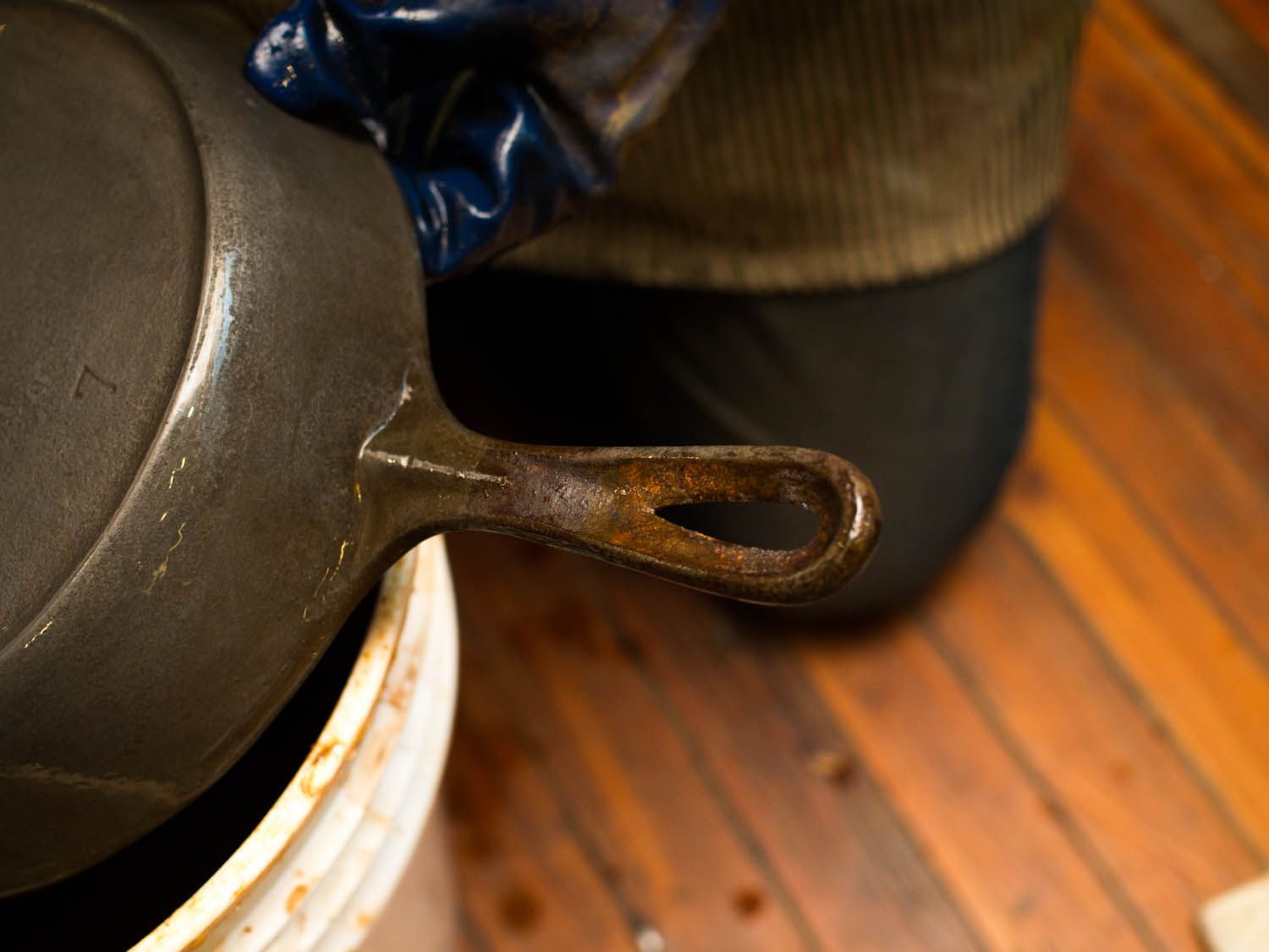 A rusted handle of a cast iron skillet.