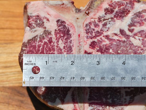 An image of the author measuring the width of the tenderloin from its edge to the T-bone with a ruler.