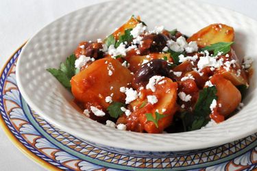 Greek potato and olive stew in a white bowl 