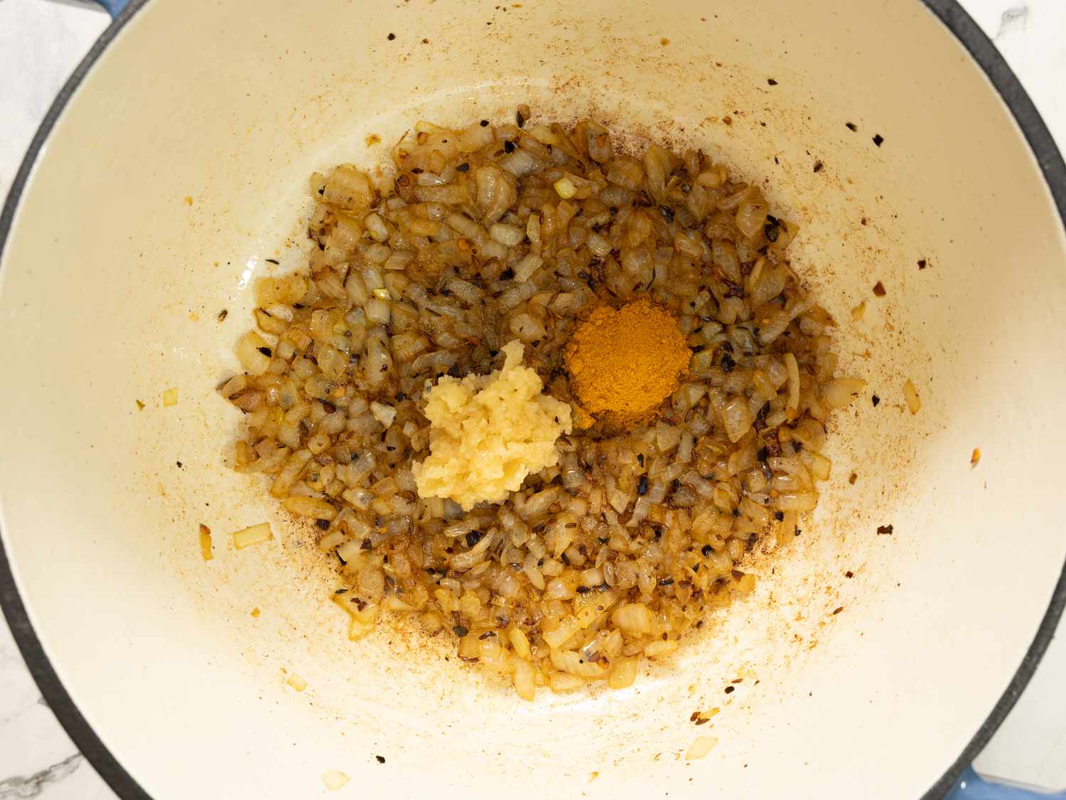 Cooking onions with turmeric and garlic in a pan