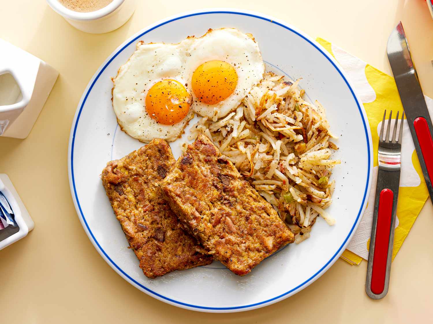 Overhead view of scrapple on a plate with eggs and hashbrowns