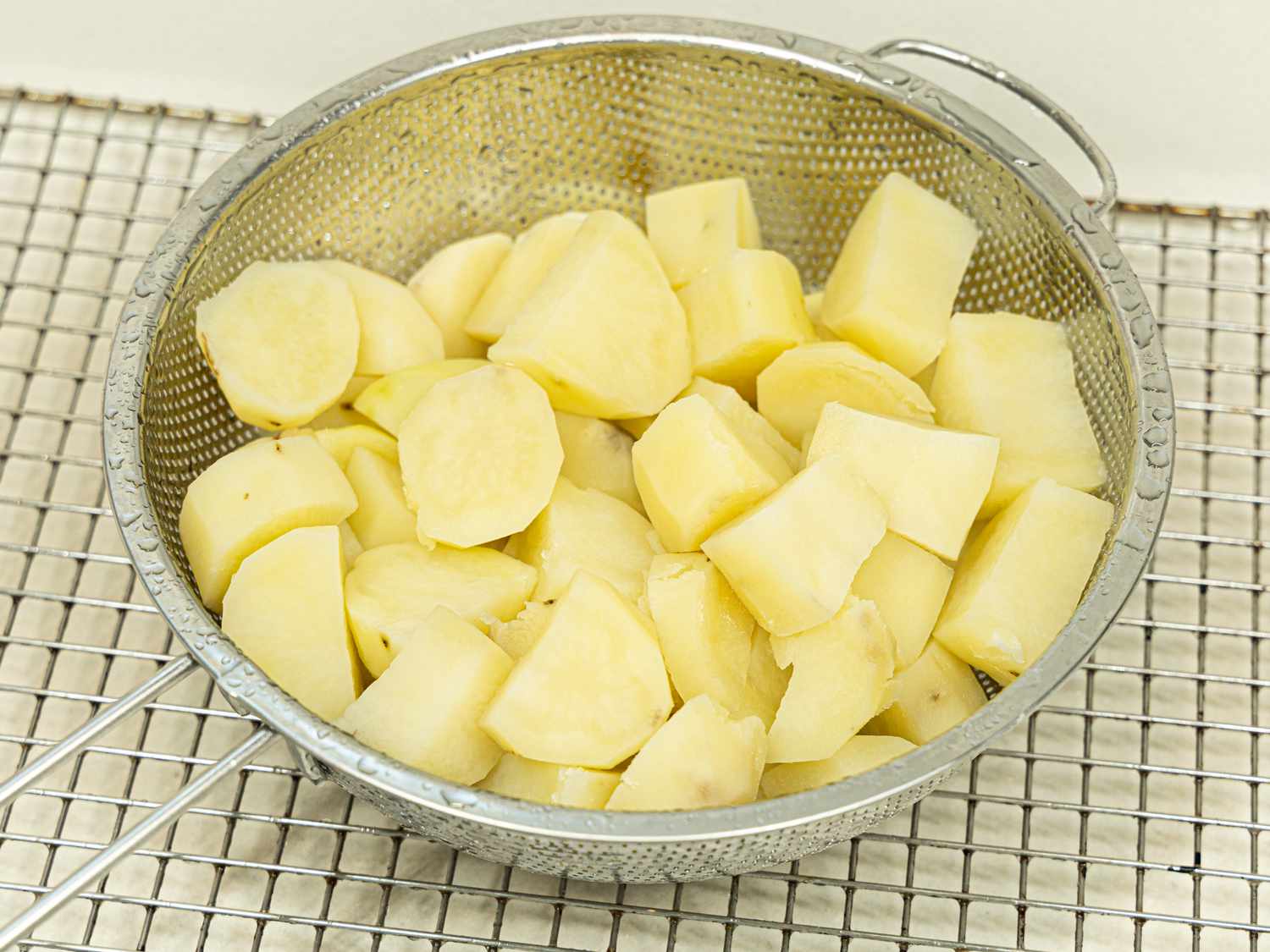 Overhead view of cooked potatoes in a collander