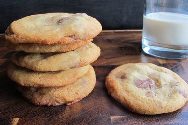 Chewy malted chocolate chip cookies, stacked next to a glass of milk.