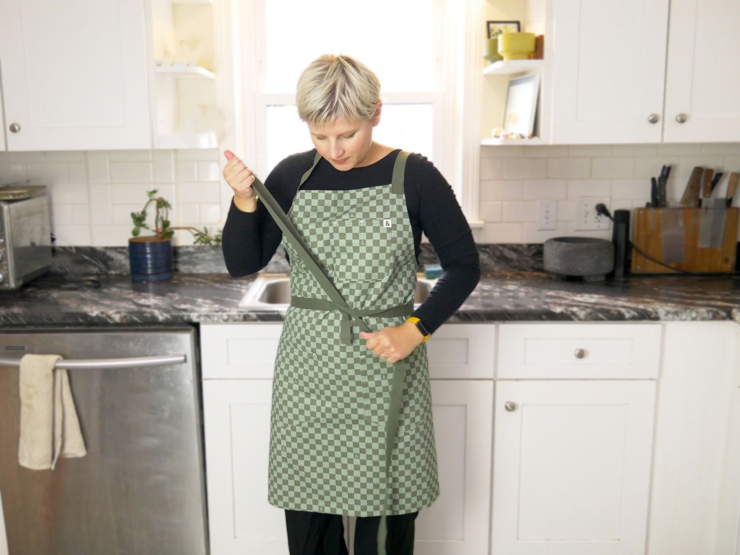 A person trying on an apron and tying it