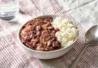 New Orleans-Style Red Beans and Rice served in a bowl on a patterned table cloth.
